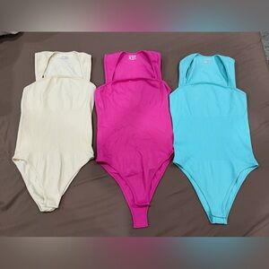 Set of Three Bodysuits in Pink, Cream, and Blue